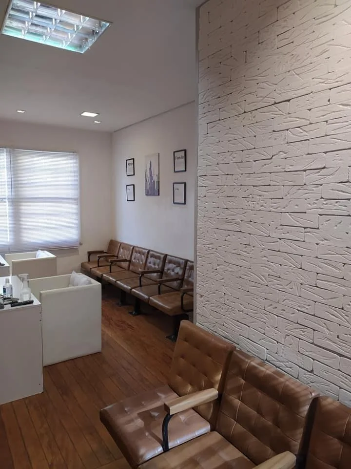 Sala de espera com cadeiras e parede de tijolos