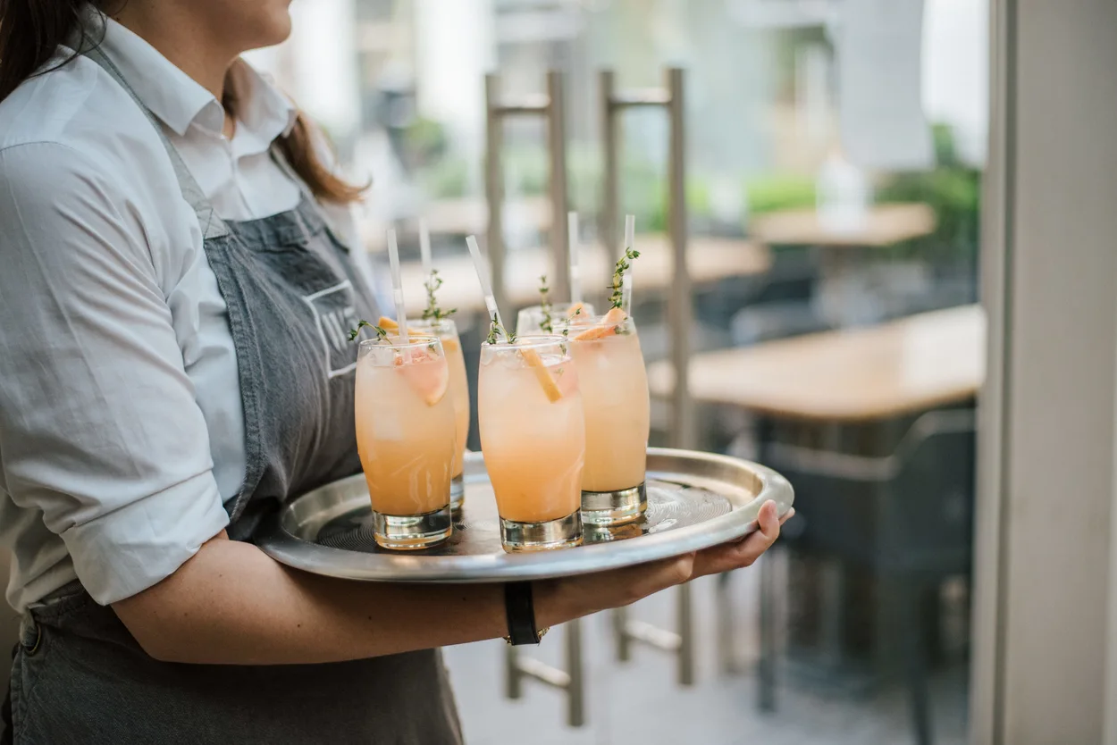 Profissional servindo bebidas em uma bandeja